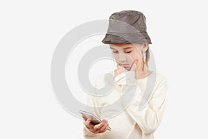 Cute boy using a smart phone over white background. Pensive young boy with a serious face thinking about a question