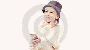 Cute boy using a smart phone over white background. Smart kid holding a mobile phone. Technology, lifestyle and people concept