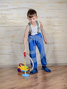 Cute boy using toy vaccuum