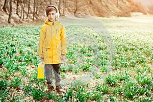 Cute boy walking at nature. Kid with headphones relaxing in the spring park
