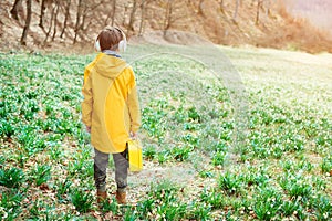 Cute boy walking at nature. Kid with headphones relaxing in the spring park