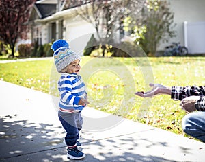 Cute boy walking on a sidewalk reaching for a free handout photo
