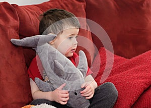 cute boy watching tv on the couch with face in strawberry juice