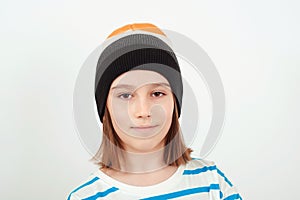 Cute boy wearing stylish woolen hat. Kid posing over white background