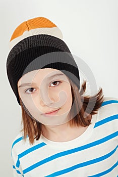 Cute boy wearing stylish woolen hat. Kid posing over white background