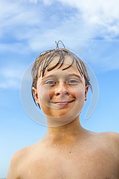 Cute boy with wet hair at the beach