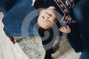 Cute boy and winter sweater. Low perspective portrait of cute little boy smiling at camera