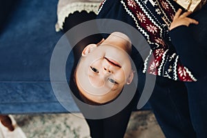 Cute boy and winter sweater. Low perspective portrait of cute little boy smiling at camera