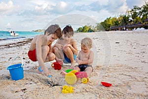 Cute  boys playing with beach toys on tropical beach