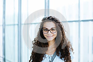 Cute brazilian girl with curly hair and casual clothing smiles for the camera