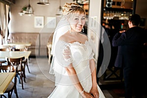 Cute bride in a wedding dress at cafe