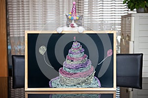 A cute british shorthair cat behind a blackboard with birthday cake celebrating her 1-year-old birthday