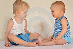 Cute brothers are sitting and looking each other.