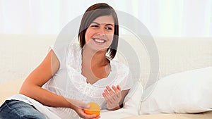 Cute brownhaired lady smelling an orange