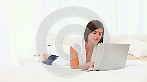 Cute brownhaired woman using her laptop