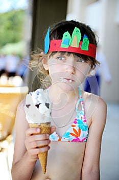 Cute brunette little girl eating ice cream