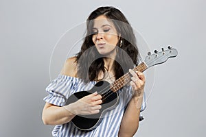 Cute brunette playing ukulele