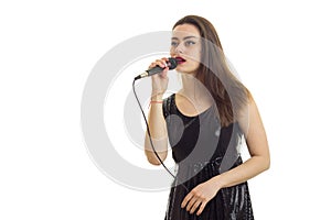 Cute brunette woman in elegnat black dress with microphone