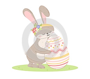 Cute bunny with flowers hugging a decorated Easter egg. Vector isolated cartoon illustration of a rabbit in a clearing