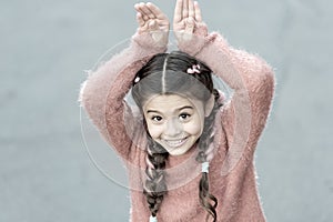 Cute bunny. Happy easter. Holiday bunny girl posing like rabbit grey background. Child smiling play bunny role. Playful