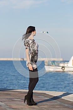 Cute business woman observes white boat in sea