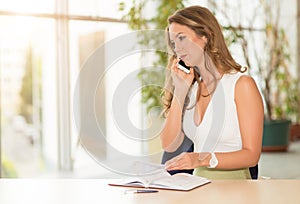 Cute business woman use her phone in office