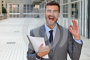 Cute businessman winking and giving an OK sign