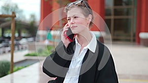 Cute businesswoman having conversation on smartphone outdoors. portrait of beautiful caucasian female business person