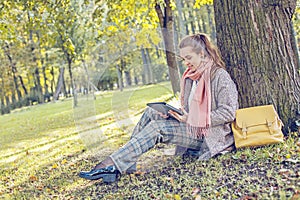 Cute businesswoman with tablet laptop at work outdoors in park