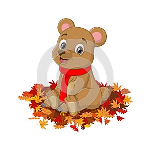 Cute cartoon bear in red scarf sits autumn leaves