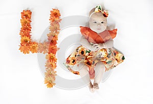 cute Caucasian 4-month-old baby girl in a dress. 4-month-old baby