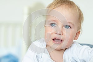 Cute caucasian blond toddler boy portrait crying at home during hysterics. Little child feeling sad. Small pensive baby after photo