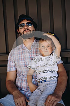 Cute caucasian boy sitting on laps of his father