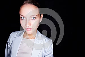 Cute Caucasian business woman isolated on black background. Lovely young business woman smiling against a black