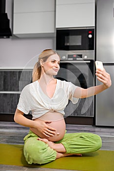 Cute Caucasian Female Take Photo On Mobile Phone, After Doing Yoga Exercises During Pregnancy