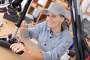 cute caucasian female worker repairing bicycle photo