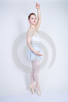 Cute caucasian girl in ballet clothes learning to be a ballerina on a white background in the Studio. plus size young woman dreams