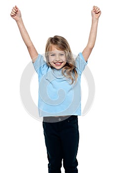 Cute caucasian girl celebrating with raised arms
