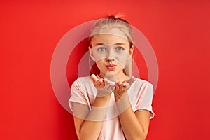 Cute caucasian kid girl sending blowing kiss at camera