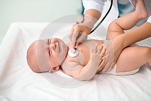 Cute Caucasian newborn undergoing a medical examination