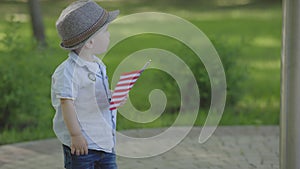 cute caucasian toddler child kid holding American Flag outdoors, baby standing