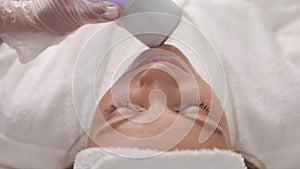 A cute Caucasian woman receives a radiofrequency face and neck lifting procedure at a cosmetology clinic. Non-surgical