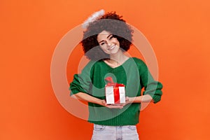 Cute charming angelic woman with Afro hairstyle wearing green casual style sweater and nimb over