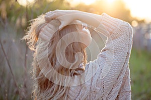 Cute charming girl in summer in the field. Young woman is happy and feels free outdoors