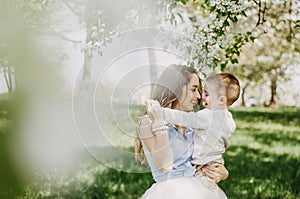 Cute cheerful child with mother play outdoors in park