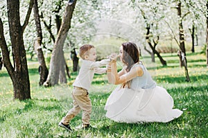 Cute cheerful child with mother play outdoors in park