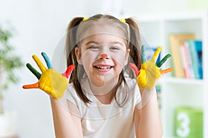 Cute cheerful child with painted hands and face