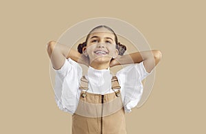 Cute cheerful little girl dreaming of something with happy expression on her face