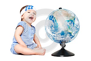 Cute cheerful little girl sitting next to world globe