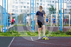 Cute cheerful smiling Boy in blue t shirt sneakers riding on yellow skateboard. Active urban lifestyle of youth, training, hobby